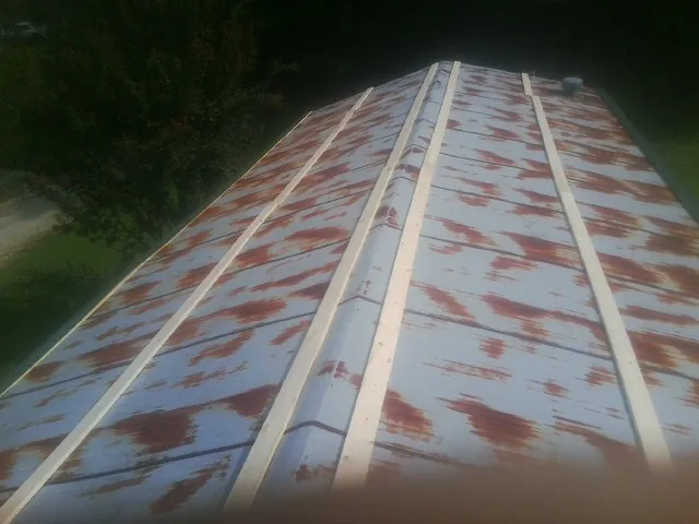Rusted metal roof panels with new wood purlins before replacement — Storm Damage Roof Repair in Oakfield by Roofing Brothers
